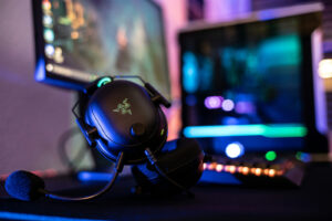 Casque gaming Razer avec microphone devant un setup PC équipé d’un éclairage RGB